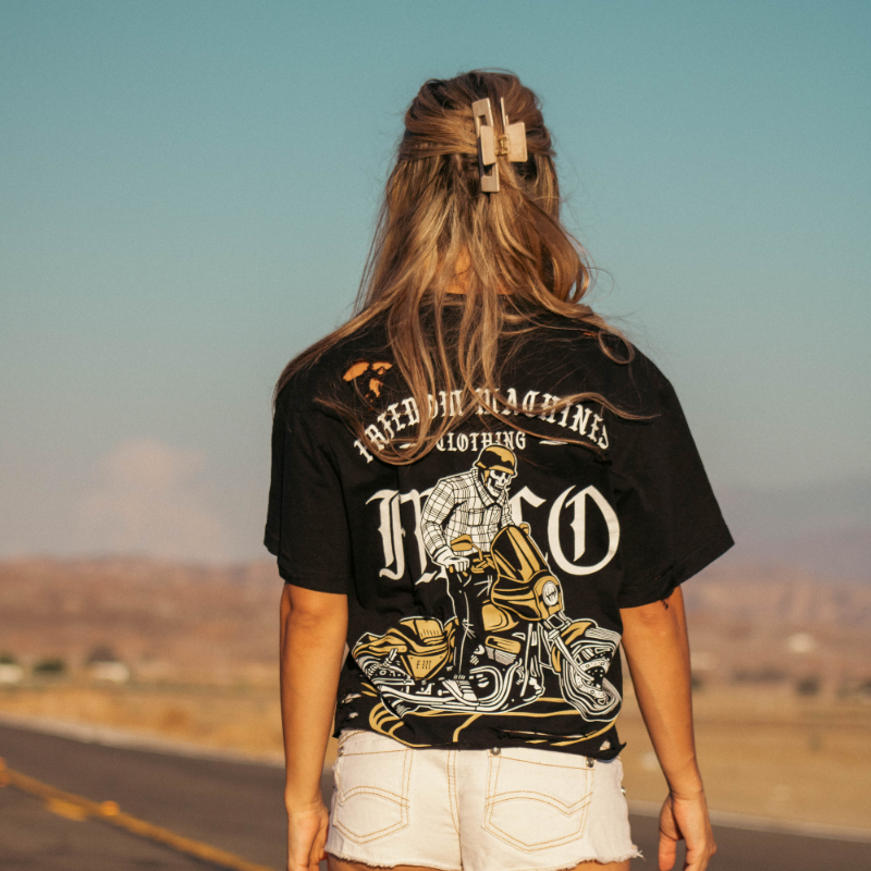 Women's black crop top cut off distressed shirt. Small freedom machine logo on front left and skeleton doing a burnout on a motorcycle on the back of the shirt hand distressed heavy weight material available in sizes small through two extra large.